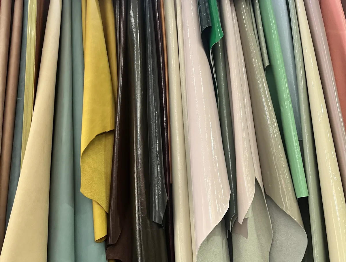Colorful top-grain cowhide leather hides in yellow, green, pink and black hanging at the Chengdu material market