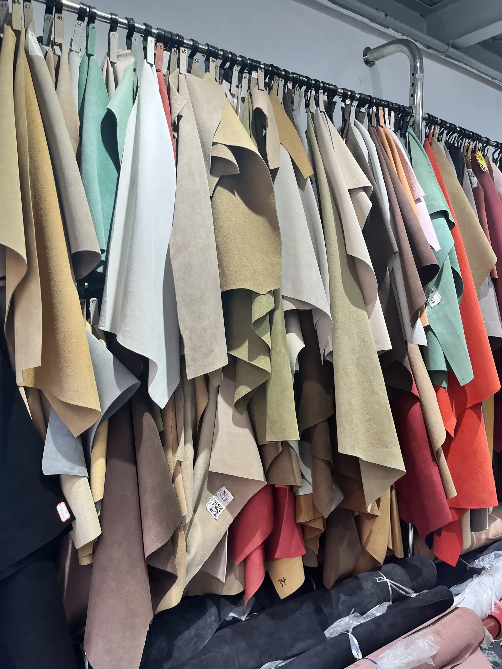 Board of leather and material swatches in muted spring colors being reviewed for a new women's shoe season